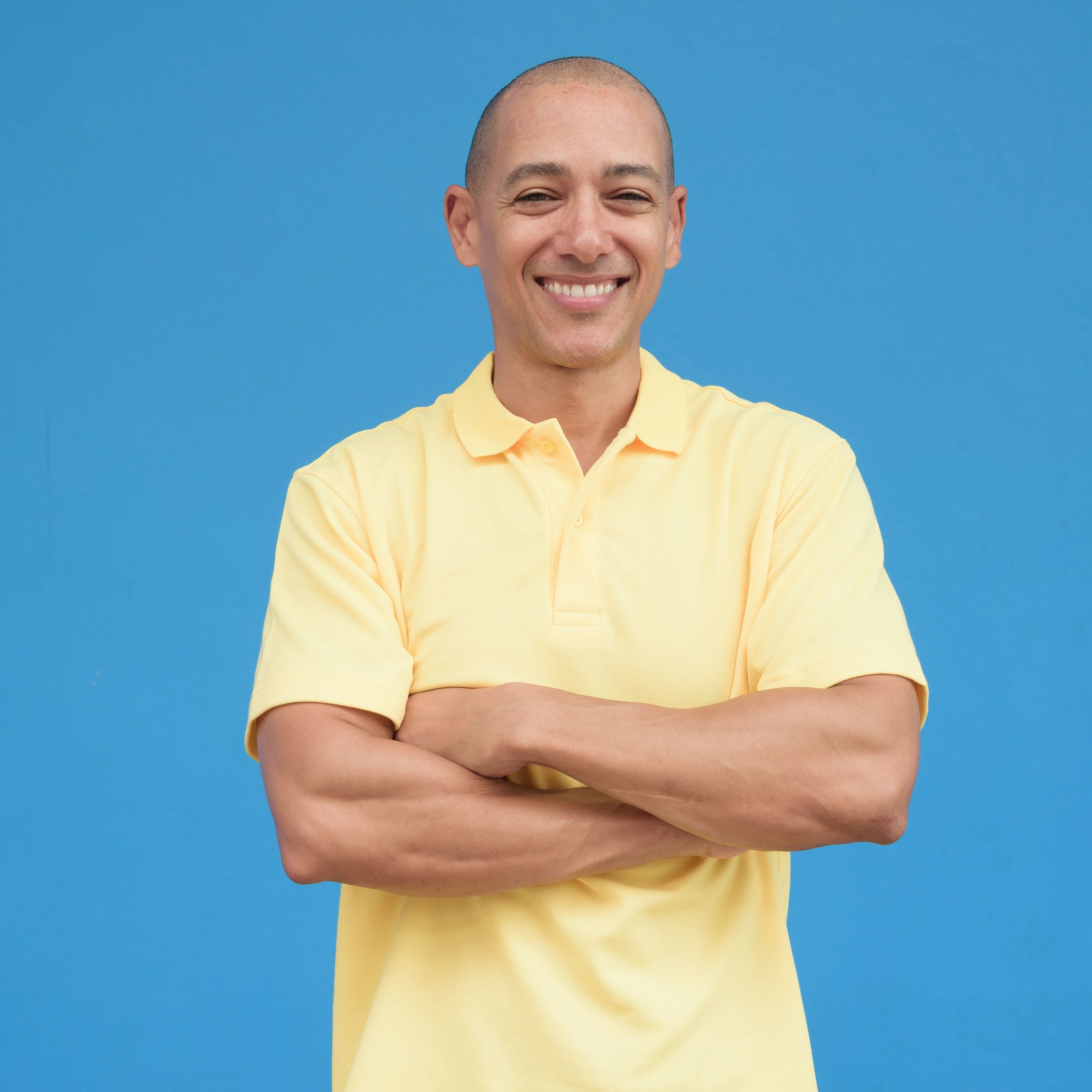 Portrait of a smiling bald man against a blue background